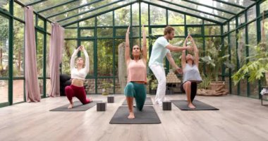 Yoga pratiği, cam evde paspasların üzerinde grup çalışması, eğitmen rehberliği. Zindelik, fitness, grup egzersizi, meditasyon, esneklik, gevşeme