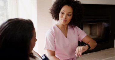 Pembe önlüklü hemşire hastayla konuşurken ukalalık taslıyor. Sağlık, teknoloji, iletişim, danışma, tıbbi