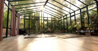 Yeşilliklerle çevrili cam evde minderlerle yoga yapıyorum. Zindelik, fitness, meditasyon, doğa, sükunet, egzersiz