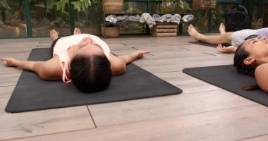 Yoga minderlerinde dinlenmek, insanlar cam evde rahatlama egzersizleri yapıyor. Meditasyon, sağlık, farkındalık, sükunet, kapalı alan, grup