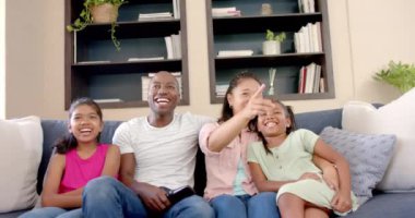 Televizyon izliyoruz, dört kişilik bir aile kanepede oturup birlikte gülüyoruz. Bağ, eğlence, birliktelik, oturma odası, mutluluk, rahatlama