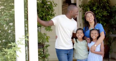 Dört kişilik gülümseyen aile evlerinin önünde bir arada, eğleniyorlar. Beraberlik, açık hava, bağlanma, mutluluk, yaşam tarzı, ebeveynlik