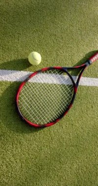 Dikey video: Tenis raketi ve top çimen kortunda, maça hazır. Spor, maç, ekipman, açık hava, atletizm, eğlence