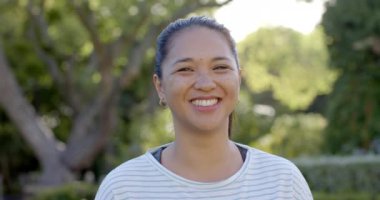 Parkta gülümseyen kadın güneşli günün ve doğanın tadını çıkarıyor. Rahatlık, mutluluk, güneş ışığı, rahatlama, huzur, neşe