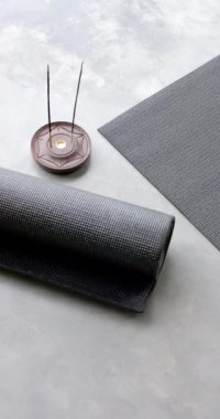 Dikey video: Yuvarlak yoga minderi ve tütsü çubukları yerde, huzurlu bir ev atmosferi yaratıyor. Meditasyon, rahatlama, sağIık, sükunet, zen, farkındalık