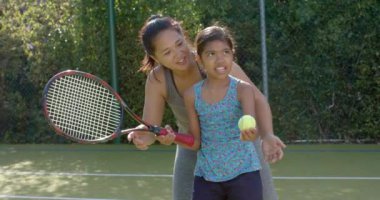 Tenis oynuyorlar, anne-kız güneşli bir günde dışarıda eğleniyorlar. aile, açık hava, bağ, spor, eğlence, spor, spor