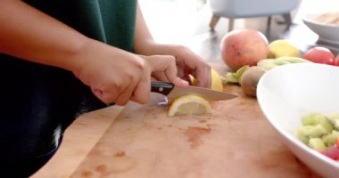 Tahtada limon dilimleri kesmek, taze meyve salatası hazırlamak. Aşçılık, mutfak, turunçgil, sağlıklı, hazırlık, aşçılık