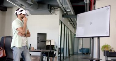 VR kulaklığı kullanarak modern ofiste verileri analiz eden adam, kopyalama uzayı. Teknoloji, sanal gerçeklik, yenilik, analiz, iş dünyası, dijital