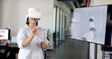 VR kulaklık kullanan bir kadın modern ofisteki sanal arayüzle etkileşimde bulunuyor. Teknoloji, yenilik, sanal gerçeklik, etkileşim, dijital, fütürist