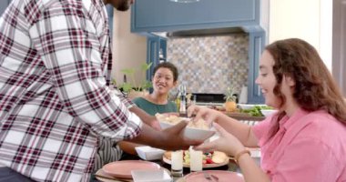 Çeşitli arkadaş grupları yemeği paylaşıyor, mutfakta birlikte vakit geçiriyorlar. Arkadaşlık, toplum, yemek, bağlılık, yaşam tarzı, kapalı alan, çok kültürlü, değişmemiş, yavaş çekim