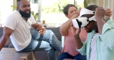 VR kulaklığı kullanarak, farklı arkadaşlar evde sanal gerçeklik deneyiminin tadını çıkarıyorlar. Teknoloji, oyun, eğlence, eğlence, grup