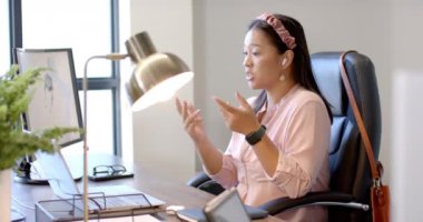 Ofiste çalışan, bilgisayarını kullanan ve iş arkadaşlarıyla görüntülü konuşma yapan bir kadın. İş, takım çalışması, işbirliği, toplantı, teknoloji, işyeri