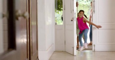 Eve koşuyorlar, heyecanlı çocuklar eve girerken aileleri onları takip ediyor. Aile, mutluluk, eve dönüş, heyecan, ebeveynlik, bağlılık