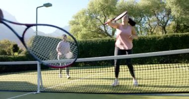 Tenis oynamak, güneşli bir günde dışarıda eğlenen iki kadın. Spor, egzersiz, fitness, eğlence, rekabet, takım çalışması