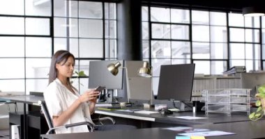 Akıllı telefon, modern ofis ortamında masa başında oturan iş kadını. technology, corporate, professional, workspace, communication, executive