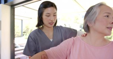 Fizyoterapist, evde terapi seansında yaşlı Asyalı kadına kol egzersizleri yaptırıyor. fizyoterapi, rehabilitasyon, sağlık, sağlık, yardım, kıdemli fitness