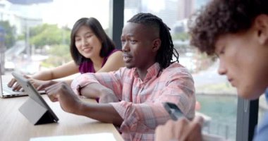 Ofiste işbirliği yapmak, çeşitli takımlar tablet ve belgeleri kullanarak projeyi tartışmak. Takım çalışması, işbirliği, iş dünyası, beyin fırtınası, teknoloji, çeşitlilik