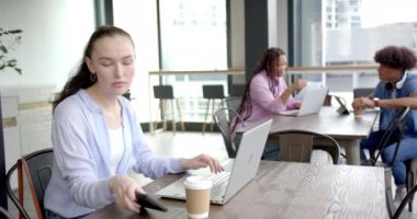 Dizüstü bilgisayar kullanarak ve sesli mesaj kaydederek modern ofis alanında çalışan bir kadın. Teknoloji, iletişim, çalışma alanı, iş, meslek, şirket