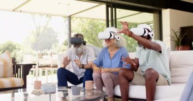 VR kulaklıkları kullanarak, kıdemli arkadaşlar sanal gerçeklik deneyiminin tadını çıkarıyorlar. Teknoloji, oyun, yaşlılar, arkadaşlık, eğlence, kahkaha