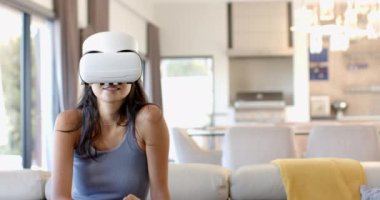 VR kulaklığı, modern oturma odasındaki koltukta oturan kadın, fotokopi odası. Teknoloji, sanal gerçeklik, rahatlama, yenilik, yaşam tarzı, ev