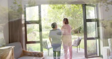 Kıdemli Asyalı kadın direniş bandıyla egzersiz yapıyor, evde fizyoterapistin yardımıyla. Yaşlılar, egzersizler, spor, spor, fizyoterapi, sağlık hizmetleri