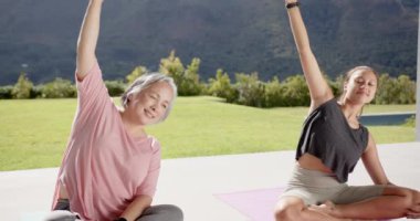 Yoga pratiği yapmak, iki kadının doğayı esnetmesi ve birlikte eğlenmesi, kopyalama alanı. Sağlık, fitness, egzersiz, meditasyon, arkadaşlık, rahatlama