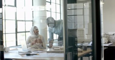 Modern ofiste iş birliği, iş arkadaşları kahve ve dizüstü bilgisayarla projeyi tartışıyor. Takım çalışması, işbirliği, toplantı, beyin fırtınası, şirket, kahve molası