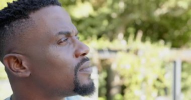 Gülümseyen ve uzaktan bakan, dışarıda huzurlu bir anın tadını çıkaran, kopyalayan bir adam. Rahatlama, huzur, tefekkür, doğa, sükunet, mutluluk.