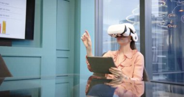 VR kulaklık ve tablet kullanan modern ofis ortamında çalışan bir kadın. Teknoloji, sanal gerçeklik, uzaktan çalışma, yenilik, iş, profesyonel