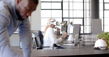 VR kulaklık kullanan, modern ofis ortamında masa başında çalışan bir kadın. Teknoloji, sanal gerçeklik, yenilik, çalışma alanı, iş dünyası, profesyonel