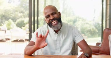 Masada sakallı, gülümseyen bir adam, arkadaşlarıyla sohbet ediyor. Sosyalleşme, mutluluk, sakal, eğlence, sıradan, toplanma