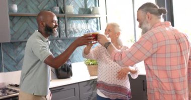 Kahveyi seviyor, modern mutfakta kıdemli arkadaşlar gülüyor ve sohbet ediyor. Arkadaşlık, sosyalleşme, eğlence, yaşam tarzı, yaşlılar, sohbet