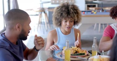 Öğle yemeği yiyor, çeşitli arkadaşlar içeride yemek ve içeceklerin tadını çıkarıyor. Arkadaşlık, yemek, restoran, yemek, kutlama, sosyalleşme