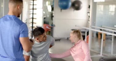 Engelli rehabilitasyonunda, terapist fizik tedavi sırasında sırt ağrısı olan adama yardım ediyor. Fizyoterapist, fizyoterapi, rehabilitasyon, sağlık hizmetleri, tıbbi yardım, değişmemiş, yavaş çekim