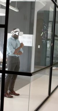 Dikey video: Modern ofiste sanal içerikle uğraşan işadamı VR kulaklığı kullanıyor. Teknoloji, yenilik, sanal gerçeklik, dijital, etkileşim, geleceksel