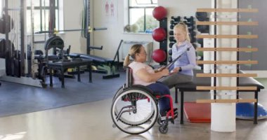 Rehabilitasyon merkezinde, tekerlekli sandalye egzersizi, direniş bandı ve terapist yapan bir kadın. fizyoterapi, fizik tedavi, egzersiz, sağlık, destek, güç, değişmemiş, yavaş çekim