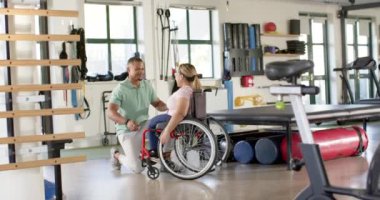 Tekerlekli sandalyedeki felçli kadına yardım etmek, rehabilitasyon egzersizlerine rehberlik eden fizyoterapist. fizyoterapi, sağlık hizmeti, engellilik, yardım, destek, hareket kabiliyeti, değiştirilmemiş, yavaş çekim