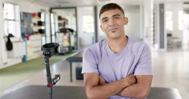 Koltuk değnekli bir adam rehabilitasyon merkezinde oturuyor ve güvenle gülümsüyor. protez, sağlık, tedavi, terapi, güven, iyileşme, değiştirilmemiş, yavaş çekim