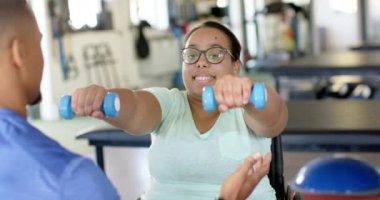 Tekerlekli sandalyede felçli bir kadın klinikteki rehabilitasyon sırasında terapistle konuşuyor. terapi, sağlık hizmeti, fizyoterapi, iyileşme, tıbbi destek, değişmemiş, yavaş çekim