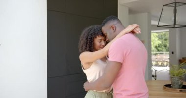 Kucaklaşan ve gülümseyen bir çift, evde mahremiyetin tadını çıkarıyor. Aşk, samimiyet, birliktelik, mutluluk, romantizm, ilişki