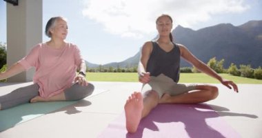 Yoga pratiği, dağ manzaralı paspasların üzerinde gerinen kadınlar. refah, meditasyon, fitness, sağlık, doğa, egzersiz