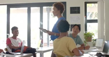 Lisede öğrencilerle uğraşan bir öğretmen sınıf tartışmasında el kaldırıyordu. Eğitim, öğretim, öğrenme, etkileşim, müdahale, katılım