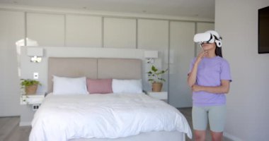 VR kulaklığı kullanarak, modern yatak odasında sanal gerçekliği keşfeden kadın, kopyalama uzayı. Teknoloji, yenilik, sürükleyici, dijital, eğlence, fütüristik