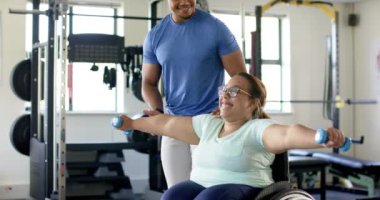 Tekerlekli sandalyedeki felçli bir kadına yardım etmek, rehabilitasyon egzersizlerine rehberlik eden kişisel antrenör. yardım, sağlık, terapi, rehberlik, destek, iyileşme, değiştirilmemiş, yavaş çekim