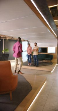 Dikey video: İş toplantısı, üç meslektaşın modern ofis alanındaki projeyi tartışıyor. Takım çalışması, işbirliği, beyin fırtınası, tartışma, şirket, profesyonel