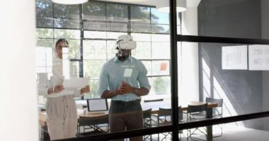 Projede işbirliği, modern ofis alanındaki cam tahtaya yazı yazan meslektaşlar. Takım çalışması, beyin fırtınası, işbirliği, iş dünyası, yaratıcılık, yenilik