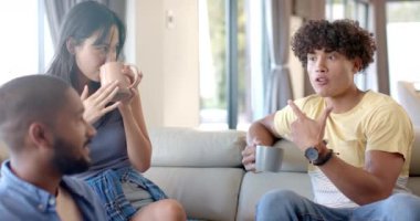 Evde, çeşitli arkadaşlar takılıyor, gülümsüyor ve kanepede otururken kahve içiyor. Kapalı alan, rahatlama, gündelik konuşma, kaynaşma, sosyalleşme