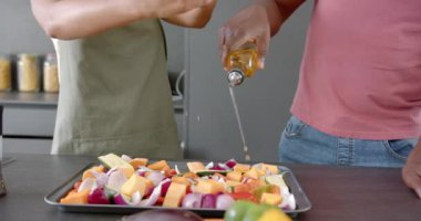 Sebze hazırlamak, baharat ve yağ serpiştirmek mutfakta pişirme tepsisinde. Aşçılık, hazırlık, malzemeler, birliktelik, sağlıklı, aşçılık