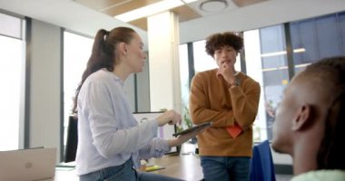 Proje fikirleri tartışıyorlar, meslektaşlar ofiste tablet ve dizüstü bilgisayarla işbirliği yapıyorlar. Takım çalışması, işbirliği, beyin fırtınası, teknoloji, iş dünyası, verimlilik