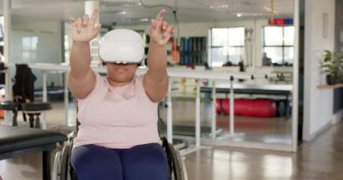 VR kulaklık kullanan, tekerlekli sandalye egzersizi yapan, rehabilitasyon merkezi, fotokopi alanı olan bir kadın. egzersiz, terapi, sağlık hizmeti, maluliyet, teknoloji, fitness, değişmemiş, yavaş çekim